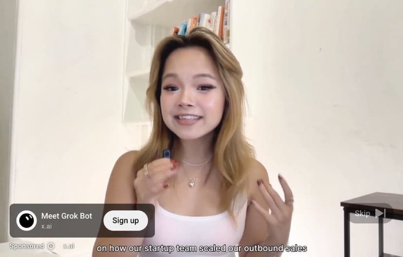 A sponsored video ad for Grok from x.ai. A creator talks to camera in a plain room. A card in the lower corner reads Meet Grok Bot with a Sign up button, marked Sponsored, over a caption about scaling a startup team's outbound sales.
